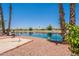 Picturesque backyard with lake views, complemented by desert landscaping and mature palm trees at 10526 W Tonopah Dr, Peoria, AZ 85382