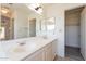 Bright bathroom featuring a double sink vanity with a large mirror and view to an attached closet at 10526 W Tonopah Dr, Peoria, AZ 85382