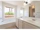 Bright bathroom featuring a soaking tub and double sink vanity with a large mirror at 10526 W Tonopah Dr, Peoria, AZ 85382