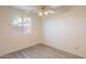 Bright bedroom features a window, neutral walls and modern gray flooring at 10526 W Tonopah Dr, Peoria, AZ 85382