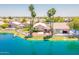 Back exterior of home on the lake with a patio, boat dock, and mature trees at 10526 W Tonopah Dr, Peoria, AZ 85382