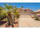 Front exterior showcasing a two-car garage and desert landscaping with a palm tree at 10526 W Tonopah Dr, Peoria, AZ 85382