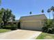 Charming single-story home with a spacious driveway, manicured landscaping, and beautiful palm trees at 10647 W Campana Dr, Sun City, AZ 85351