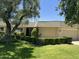 Well-maintained single-story home featuring manicured hedges and mature trees in a serene setting at 10647 W Campana Dr, Sun City, AZ 85351