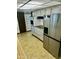 Kitchen featuring stainless steel refrigerator, white cabinets, and tile flooring at 10647 W Campana Dr, Sun City, AZ 85351