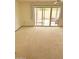 Bright living room with neutral carpet and sliding glass doors to outdoor patio area at 10647 W Campana Dr, Sun City, AZ 85351