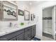 Bathroom with gray vanity, double sinks, large mirrors, and a large glass enclosed shower at 10662 E Carol Ave, Scottsdale, AZ 85258