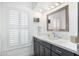 Stylish bathroom featuring a gray vanity with quartz countertop, plantation shutters, and contemporary fixtures at 10662 E Carol Ave, Scottsdale, AZ 85258