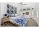 Bright bedroom with soft carpet, a bed with blue floral comforter, and two arched windows with white shutters at 10662 E Carol Ave, Scottsdale, AZ 85258