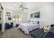 Bedroom features gray carpet, ceiling fan, a single bed, blue sofa, and white shutters on the window at 10662 E Carol Ave, Scottsdale, AZ 85258