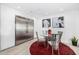 Cozy kitchen nook with a glass table, modern artwork, and stainless steel refrigerator at 10662 E Carol Ave, Scottsdale, AZ 85258