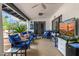 Covered outdoor patio featuring comfortable seating, a ceiling fan, and an entertainment area with a TV at 10662 E Carol Ave, Scottsdale, AZ 85258