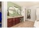 Bathroom featuring dual sinks, framed mirrors, dark wood cabinets, vanity, and natural light at 10718 E Vivid Ave, Mesa, AZ 85212