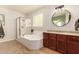 Bright bathroom showcases a soaking tub, glass shower, and dark wood vanity at 10718 E Vivid Ave, Mesa, AZ 85212