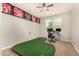 Bedroom featuring a custom putting green, sports memorabilia, and a desk area at 10718 E Vivid Ave, Mesa, AZ 85212