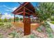 Sign at community seating area under a shaded patio with lush plants and comfortable seating at 10718 E Vivid Ave, Mesa, AZ 85212