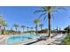 Inviting community pool area with palm trees, comfortable lounge chairs, and a clear blue swimming pool at 10718 E Vivid Ave, Mesa, AZ 85212