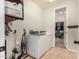Well-equipped laundry room with modern appliances and access to a spacious walk-in closet at 10718 E Vivid Ave, Mesa, AZ 85212
