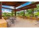 Outdoor patio with metal seating under a shaded structure, overlooking lush landscaping and blue skies at 10718 E Vivid Ave, Mesa, AZ 85212