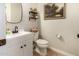 Stylish half bathroom with modern fixtures, including a white vanity, decorative mirror, and shiplap accent wall at 10718 E Vivid Ave, Mesa, AZ 85212