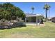 Spacious backyard featuring a covered patio and well-maintained lawn with mature trees at 10721 W Mission Ln, Sun City, AZ 85351
