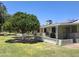 Beautiful backyard with mature trees, green lawn, and covered patio area for relaxation at 10721 W Mission Ln, Sun City, AZ 85351