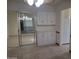 Eat-in kitchen featuring white cabinets and countertops, complemented by tile flooring and sliding glass doors at 10721 W Mission Ln, Sun City, AZ 85351