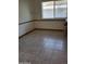 Dining room features neutral tile flooring, base trim, and natural light from window at 10721 W Mission Ln, Sun City, AZ 85351