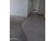 Hallway with a mix of tile and carpet flooring leading to different rooms at 10721 W Mission Ln, Sun City, AZ 85351