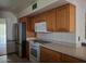 Open kitchen featuring stainless steel appliances, wood cabinets, and sleek countertops at 10721 W Mission Ln, Sun City, AZ 85351