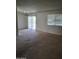 Spacious living room featuring neutral carpet, a chandelier and sliding glass door at 10721 W Mission Ln, Sun City, AZ 85351