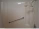 All-white shower with handheld sprayer and safety bar at 10721 W Mission Ln, Sun City, AZ 85351