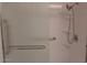 Updated shower featuring glass doors, a rainfall shower head, and built-in shelving at 10721 W Mission Ln, Sun City, AZ 85351