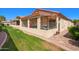 View of a cozy covered patio with a barbecue grill, next to well-maintained green lawn and a low-maintenance desert landscape at 1120 N Val Vista Dr # 113, Gilbert, AZ 85234