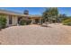 Spacious backyard featuring desert landscaping, mature trees, and a covered patio at 12927 W Shadow Hills Dr, Sun City West, AZ 85375