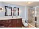 Bathroom featuring a vanity with a dark wood cabinet, granite countertops, and tiled shower at 12927 W Shadow Hills Dr, Sun City West, AZ 85375
