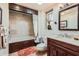 Full bathroom features a tub and shower combination, marble countertops, and dark wood cabinets at 12927 W Shadow Hills Dr, Sun City West, AZ 85375