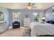 Bright bedroom with two windows, blue accent wall, wicker furniture and ceiling fan at 12927 W Shadow Hills Dr, Sun City West, AZ 85375