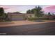 Charming single-story home with a well-manicured front yard and attached two-car garage, set against a beautiful sunrise at 12927 W Shadow Hills Dr, Sun City West, AZ 85375