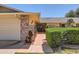 Inviting front entrance with brick accents, a pathway, mature hedges, and decorative wrought iron details, adding to the home's appeal at 12927 W Shadow Hills Dr, Sun City West, AZ 85375