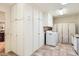 Bright laundry room featuring plenty of white storage cabinets and a white washer and dryer set at 12927 W Shadow Hills Dr, Sun City West, AZ 85375
