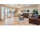 Cozy living room featuring a comfortable leather couch and access to the backyard at 12927 W Shadow Hills Dr, Sun City West, AZ 85375