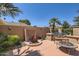 Back patio with a unique water feature, mature landscaping, and comfortable seating, perfect for outdoor entertaining and relaxation at 12927 W Shadow Hills Dr, Sun City West, AZ 85375