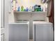 Functional laundry area includes a side-by-side washer and dryer plus shelving for cleaning supplies at 1325 E Linda Dr, Casa Grande, AZ 85122