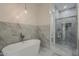 Bathroom showcasing a soaking tub, tiled accent wall, glass shower enclosure, and tiled floor at 13430 S Garnet Rd, Buckeye, AZ 85326