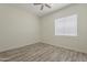 Bedroom featuring wood-look floors, neutral walls, ceiling fan, and window with blind at 13430 S Garnet Rd, Buckeye, AZ 85326