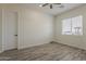 Bedroom with wood-look flooring, a ceiling fan, and natural light streaming in through the window at 13430 S Garnet Rd, Buckeye, AZ 85326