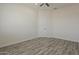 Bedroom with wood-look flooring, a ceiling fan, and two doors for easy access to other rooms at 13430 S Garnet Rd, Buckeye, AZ 85326