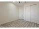 Bedroom with a ceiling fan, wood-look flooring, a closet, and a door with a lever handle at 13430 S Garnet Rd, Buckeye, AZ 85326
