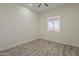 Bedroom with a ceiling fan, wood-look flooring, and a window to let in plenty of natural light at 13430 S Garnet Rd, Buckeye, AZ 85326
